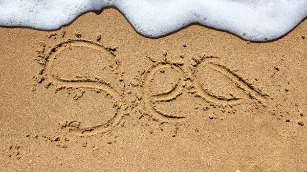 Palavra do mar escrita na areia da praia . — Fotografia de Stock