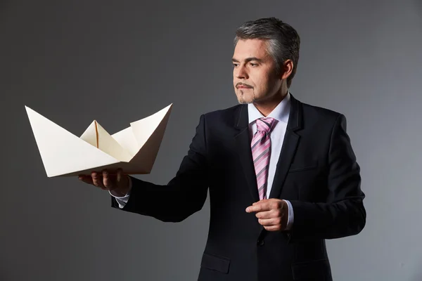 Retrato del hombre de negocios sosteniendo barco de papel — Foto de Stock