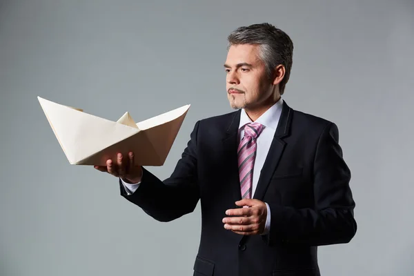 Retrato del hombre de negocios sosteniendo barco de papel — Foto de Stock