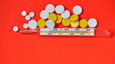 Merkür termometre ve arka plan üzerinde tıbbi ilaçlar