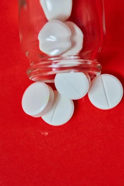 Pillen morsen uit pil fles op rood. Bovenaanzicht met kopie ruimte. — Stockfoto