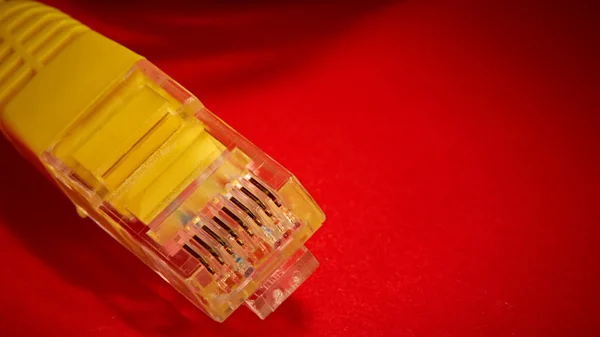 Yellow network cable on red background — Stock Photo, Image