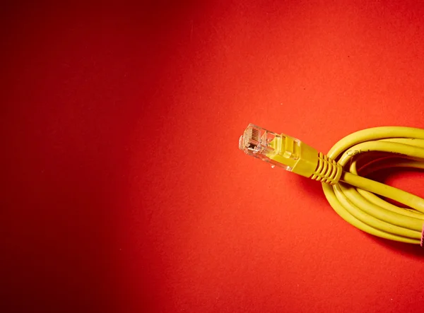 Yellow network cable on red background — Stock Photo, Image