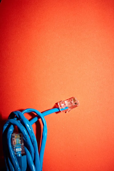 Blue network cable on red background — Stock Photo, Image