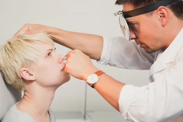 Doctor ENT revisando la oreja con otoscopio a paciente mujer —  Fotos de Stock