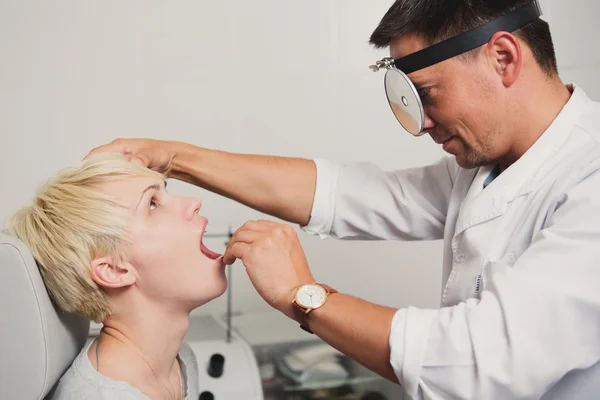 Doutor otorrinolaringologista verificando orelha com otoscópio para paciente mulher — Fotografia de Stock