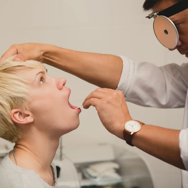 Läkare ENT kontrollerar öra med otoskop till kvinna patient — Stockfoto