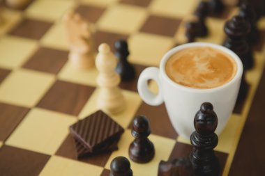 Boş zaman zaman dinlenmek veya iş stratejisi kavramı. Kahve fincanı ile satranç tablosu