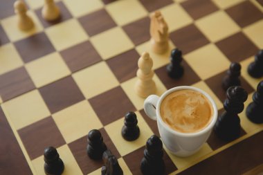 Boş zaman zaman dinlenmek veya iş stratejisi kavramı. Kahve fincanı ile satranç tablosu