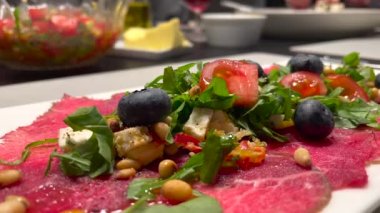 Güzel, servis edilmiş roka ve domatesli carpaccio eti yakın çekim.