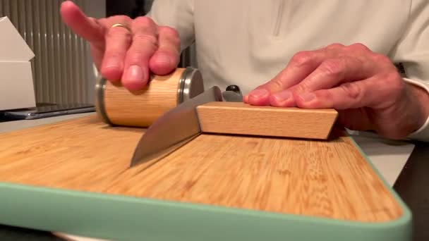 Chef hand sharpening Knife with modern grindstone on wooden board. Close up shot — Stock Video