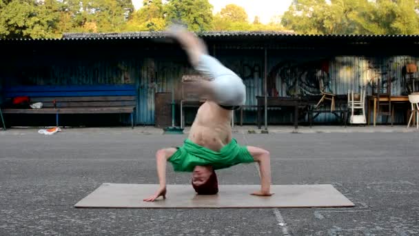 Crazy boy spins on his head on the street — Stock Video