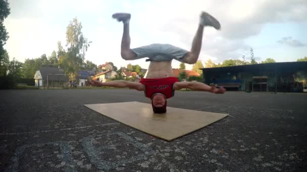 Pazzo ragazzo gira su la sua testa su il strada — Video Stock