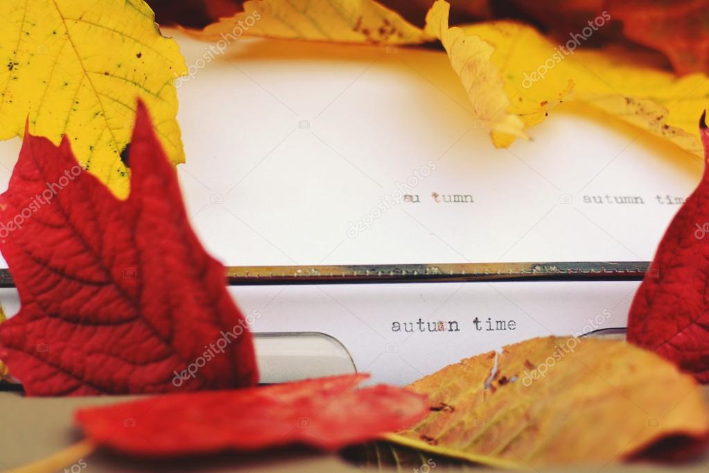Typewriter strewn with autumn leaves