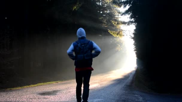 Un jeune homme marchant sur la route au lever du soleil du matin — Video