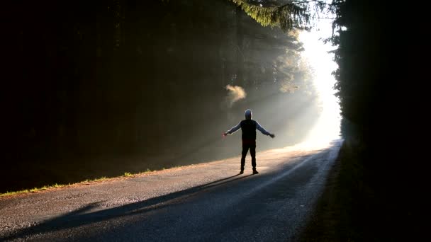 Jonge man springt op hand op de weg naar de zon — Stockvideo