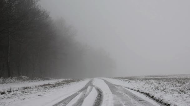 Человек бежит по зимней туманной дороге — стоковое видео