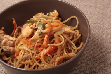 Kahverengi plaka zekâ kızarmış noodle tavuk ve sebze ile karıştırın