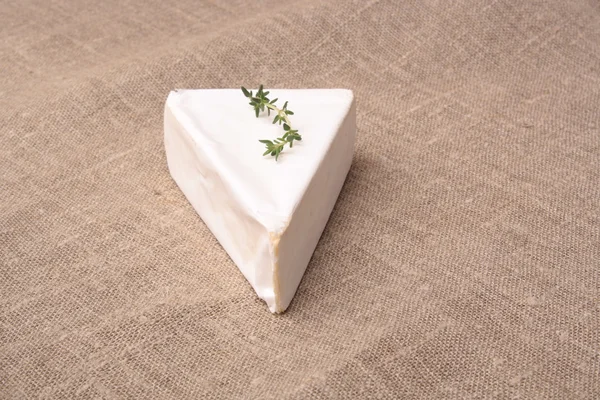 Brie peyniri bir kumaş zemin üzerine kekik ile — Stok fotoğraf