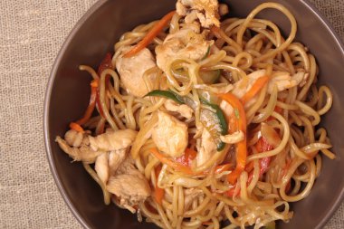 Kahverengi plaka zekâ kızarmış noodle tavuk ve sebze ile karıştırın