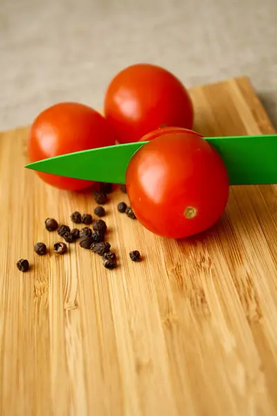 ナイフで基板の黒胡椒とトマト — ストック写真