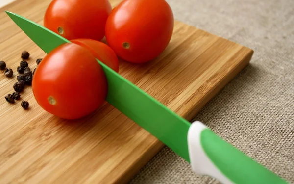 ナイフで基板の黒胡椒とトマト — ストック写真
