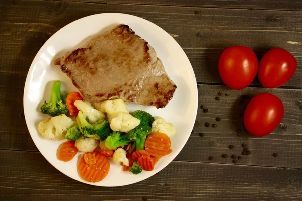 Steak se zeleninou na dřevěném pozadí — Stock fotografie