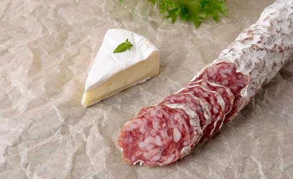 Camembert salami na tle papieru — Zdjęcie stockowe