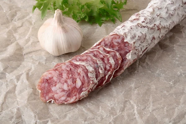 Slices of salami on paper background — Stock Photo, Image