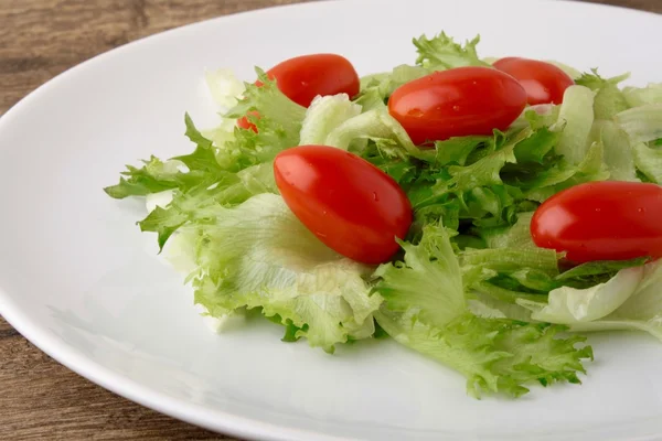 Fresh salad on a wooden background — Stock Photo, Image