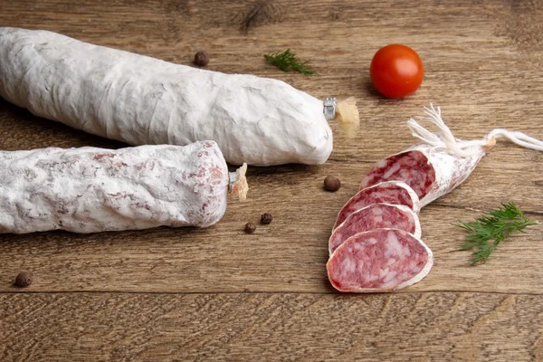 Salami slice on a wooden background — Stock Photo, Image