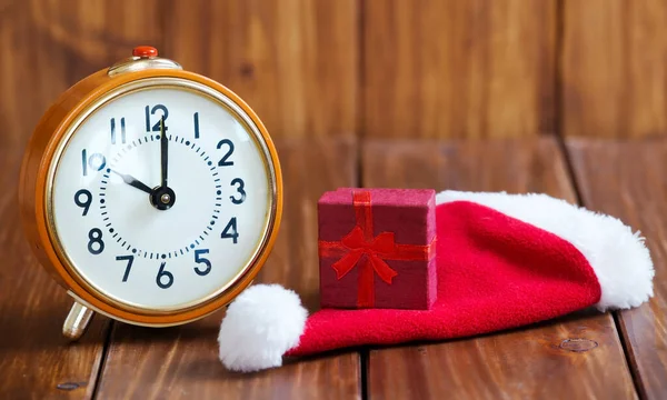 ギフト ショッピングコンセプト レトロな目覚まし時計とサンタの帽子の赤いクリスマスギフトボックスへの時間 — ストック写真