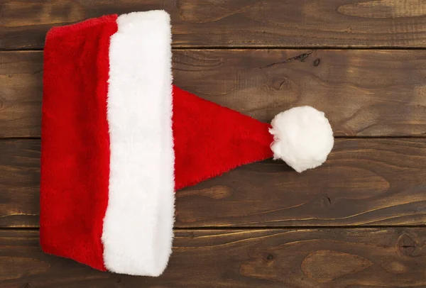 クリスマスカードのアイデア コピースパック付きの木製の背景のサンタの帽子 — ストック写真