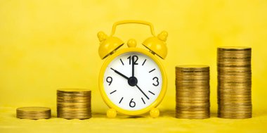 Mali özgürlük kavramı, çalar saat ve sarı arka planda altın para. Web pankartı.