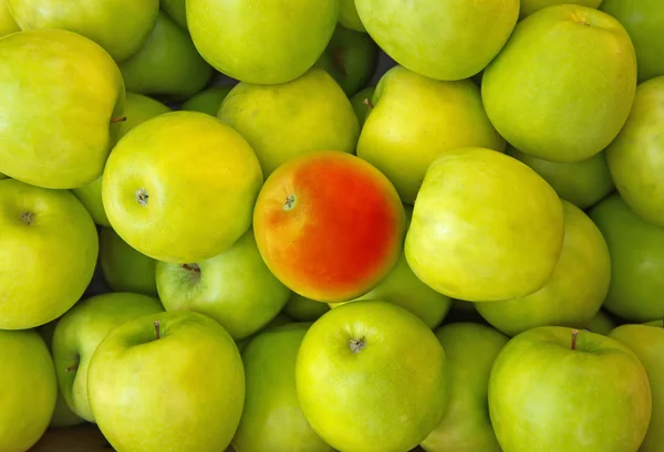 แอปเปิ้ลสีแดงตรงกลางของแอปเปิ้ลสีเขียว — ภาพถ่ายสต็อก