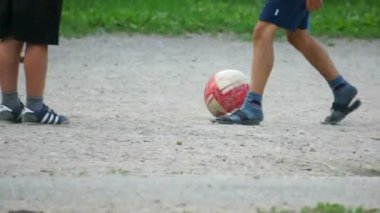 Çocuklar spor alanında topu tekmeleme