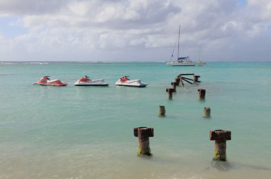 Hidrobisikletler ve yıkılmış rıhtım. Anse de Sent-An, Pointe-a-Pitre, Guadeloupe