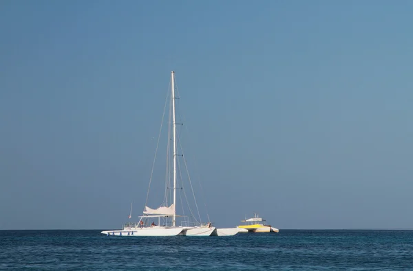 Білий тримаран у блакитному морі — стокове фото