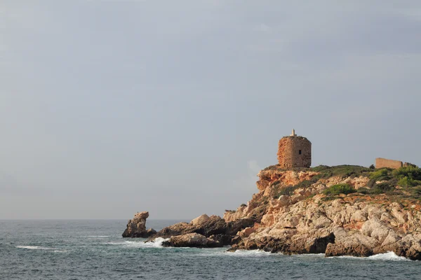 Древняя сторожевая башня на скалистом берегу моря. Иллетес, Пальма-де-Майо, Испания — стоковое фото