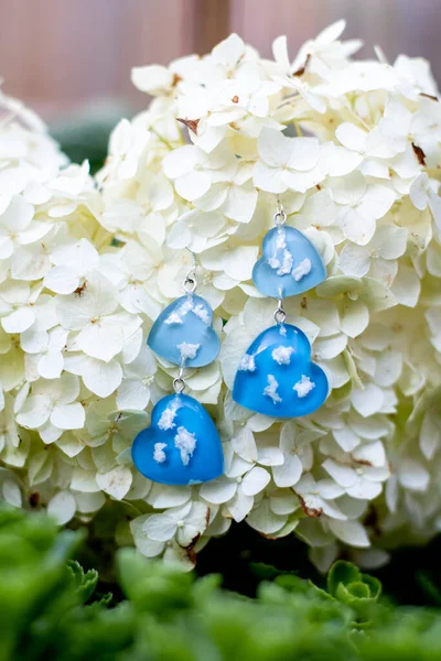 Avucundaki sevimli epoksi reçine küpeler.