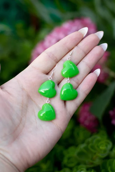 Avucundaki sevimli epoksi reçine küpeler.