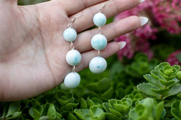 Avucundaki sevimli epoksi reçine küpeler.