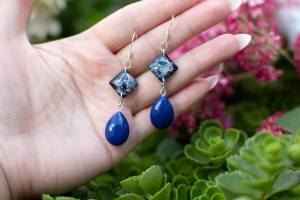 Avucundaki sevimli epoksi reçine küpeler.