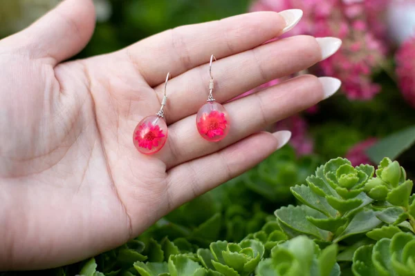 Avucundaki sevimli epoksi reçine küpeler.