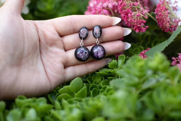 Avucundaki sevimli epoksi reçine küpeler.