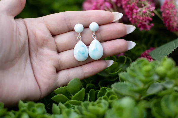 Avucundaki sevimli epoksi reçine küpeler.