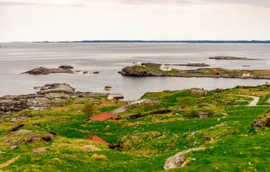Tepenin tepesinden Fjoloy kalesine ve deniz fenerine panoramik manzara, Rennesoy kommune, Stavanger, Norveç, Mayıs 2018