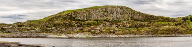 Fjoloy adasının kıyı şeridine ve en yüksek tepesine panoramik bir manzara, Rennesoy kommune, Stavanger, Norveç, Mayıs 2018