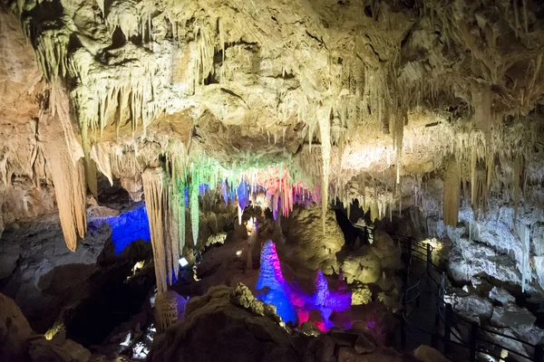 Verlichte stalactieten en stalagmieten in Ngilgi grot in River — Stockfoto