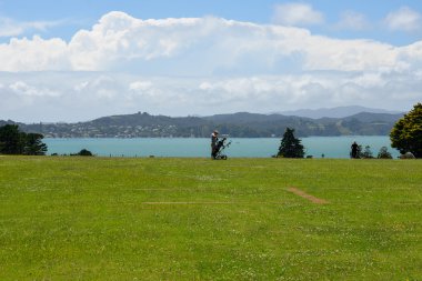 Waitangi ve Russell bir görünümünü Golf oynayan bir adam
